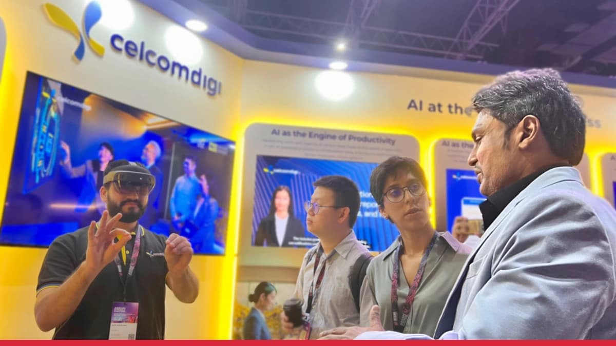 People discussing enterprise AI at the CelcomDigi booth during the ASEAN AI Summit