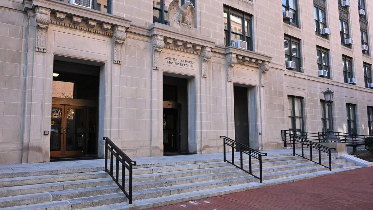 Stone entrance of the General Services Administration headquarters in Washington, with the agency name carved above the central door and granite steps below