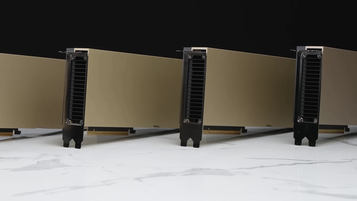 Row of gold-coloured NVIDIA H100 PCIe accelerator cards standing on a white marble surface against a black background