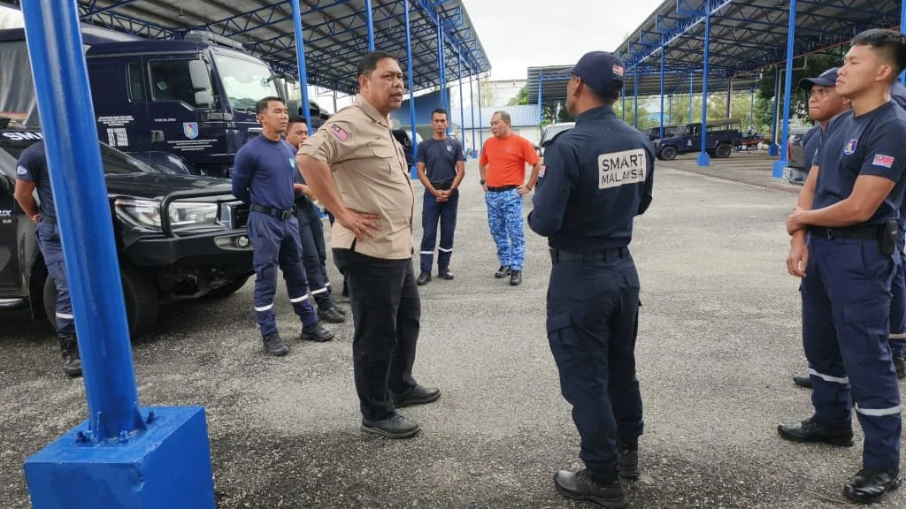 NADMA director briefs SMART Malaysia rescue personnel beside emergency response vehicles in Kelantan