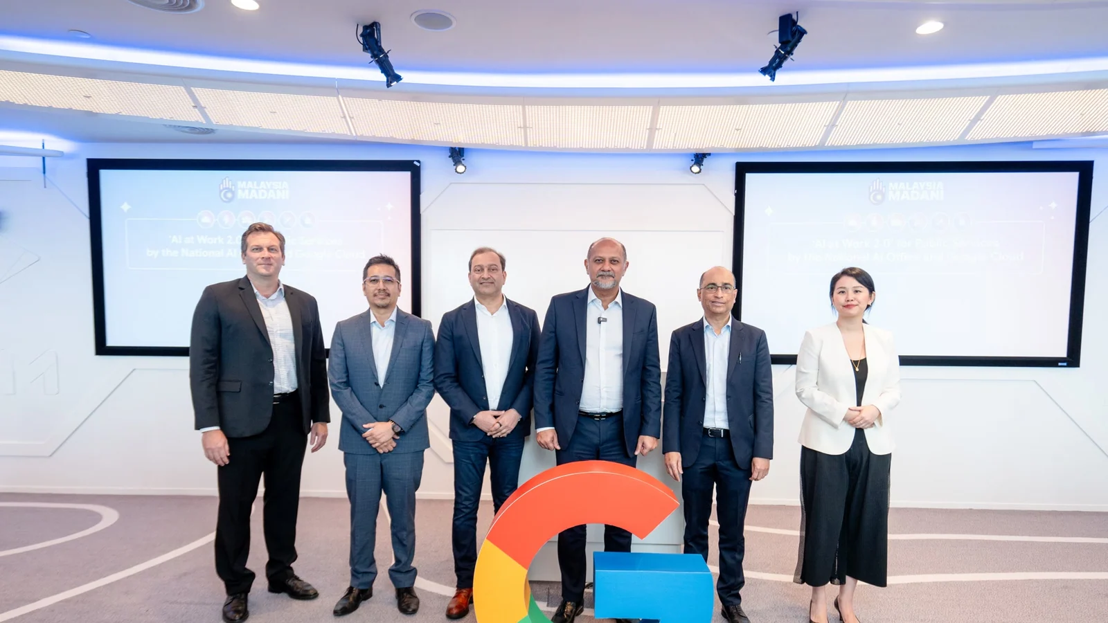 Malaysian public-sector and Google Cloud representatives stand behind a Google sculpture at the AI at Work 2.0 launch