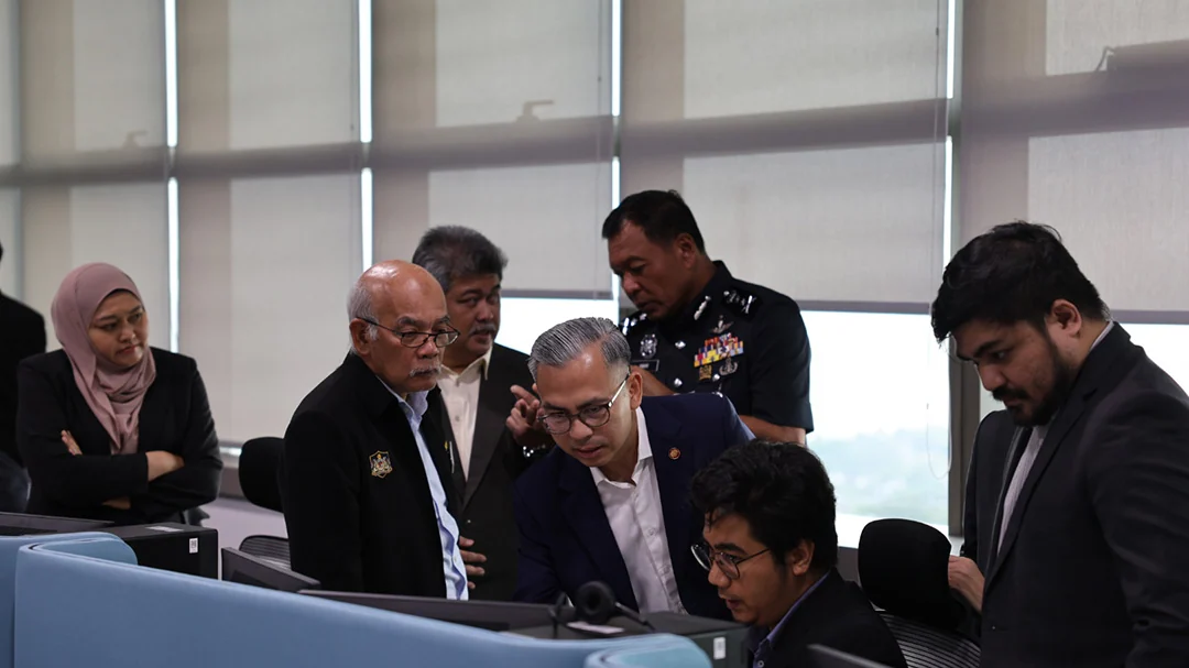 Officials review workstations during a later visit to the National Scam Response Centre
