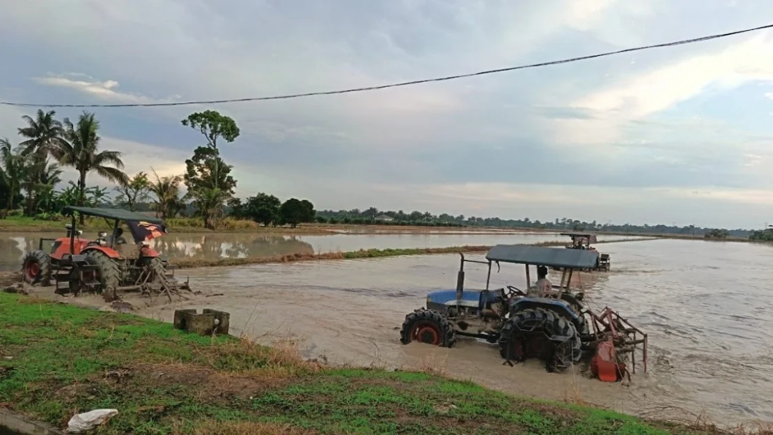 Tractors prepare Malaysian paddy fields during the later Rakan Tani rollout