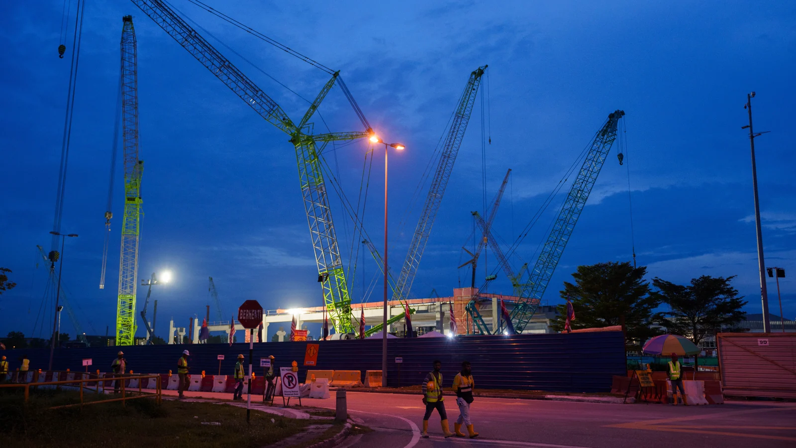 Construction workers walk outside a data-centre building under construction in Johor Bahru