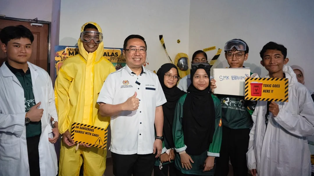 Chang Lih Kang stands with a Malaysia Techlympics student team wearing science safety equipment