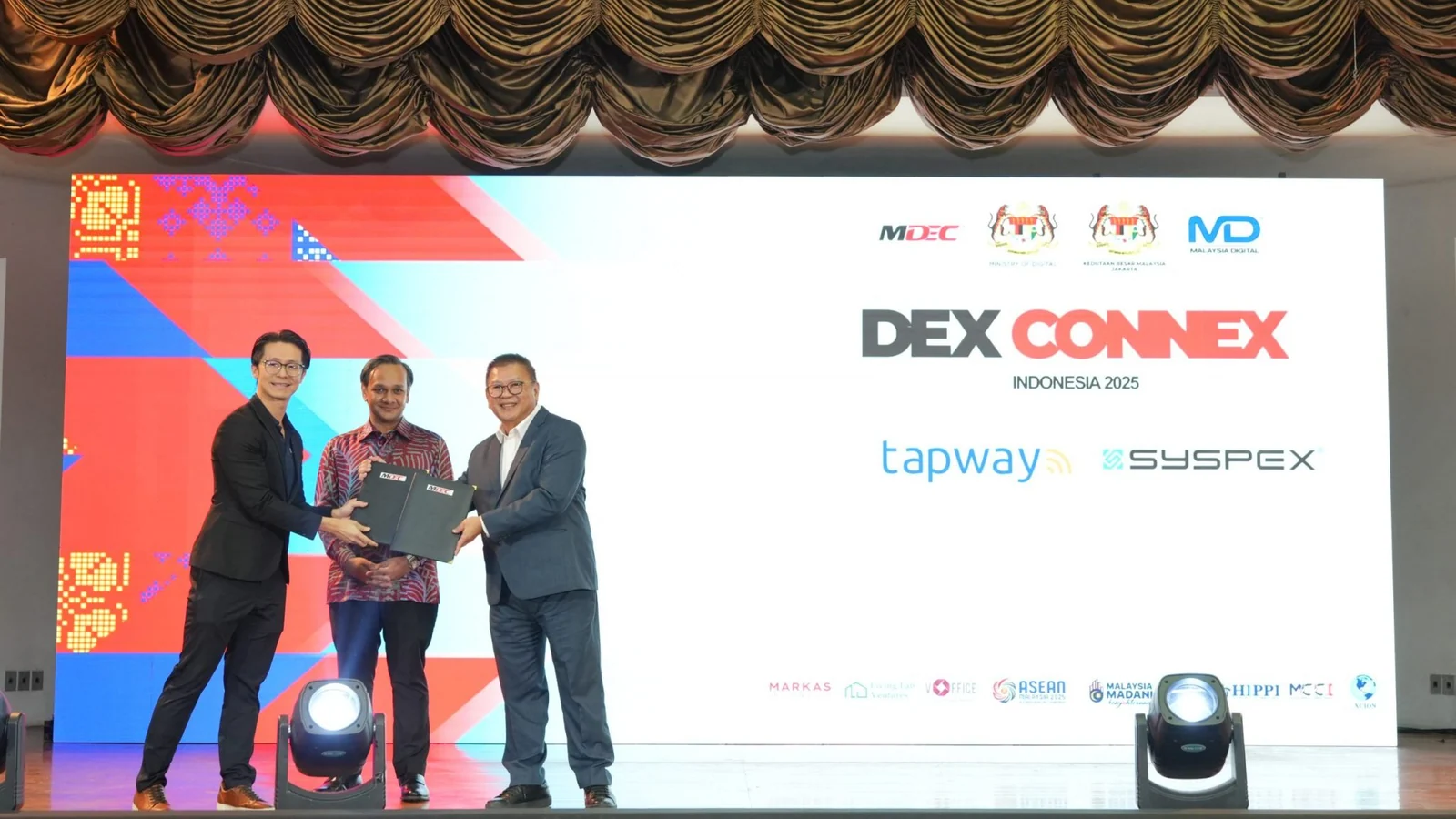Tapway and Syspex representatives exchange an AI partnership memorandum at DEX CONNEX Indonesia 2025 in Jakarta