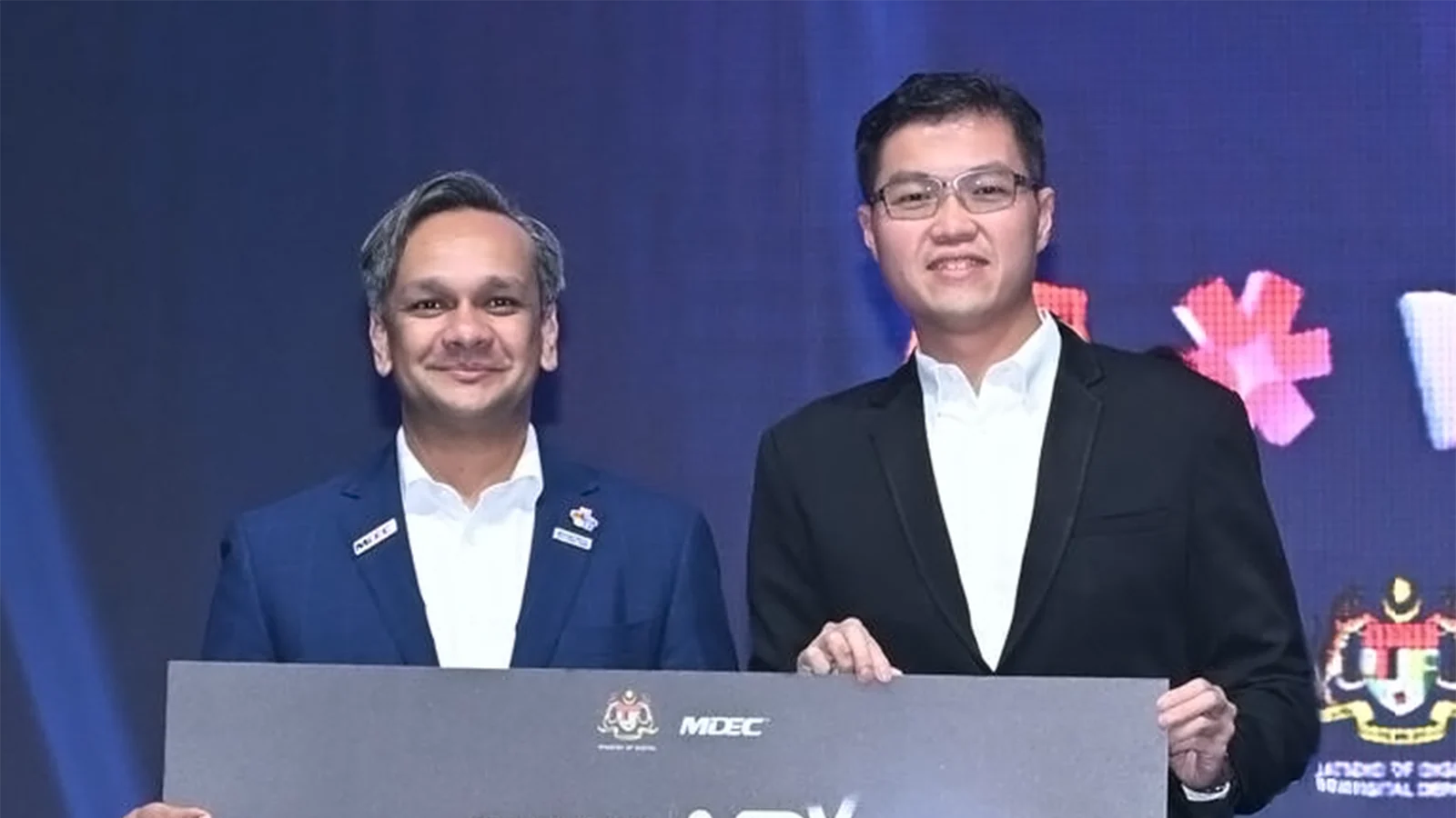 MDEC chief executive Anuar Fariz Fadzil presents an MDAG-AI award to MACROKIOSK co-founder Henry Goh