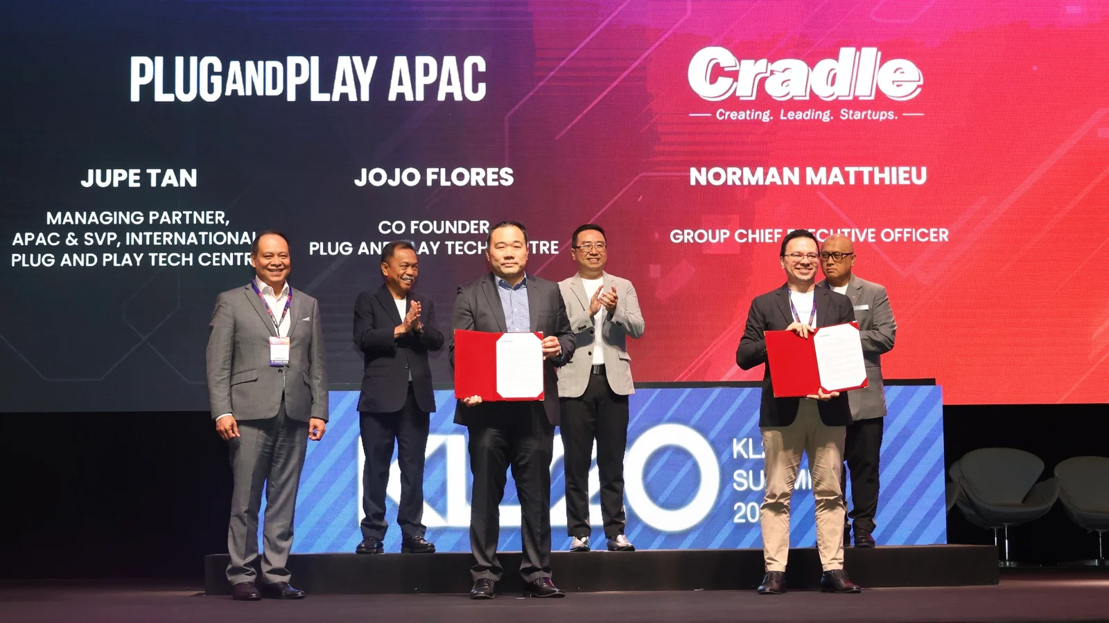 Cradle Fund and Plug and Play APAC representatives hold signed documents at a KL20 exchange ceremony on 23 April 2024
