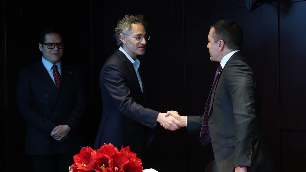 Palantir chief executive Alex Karp, centre in a dark suit, shaking hands across a table at an official meeting in Davos