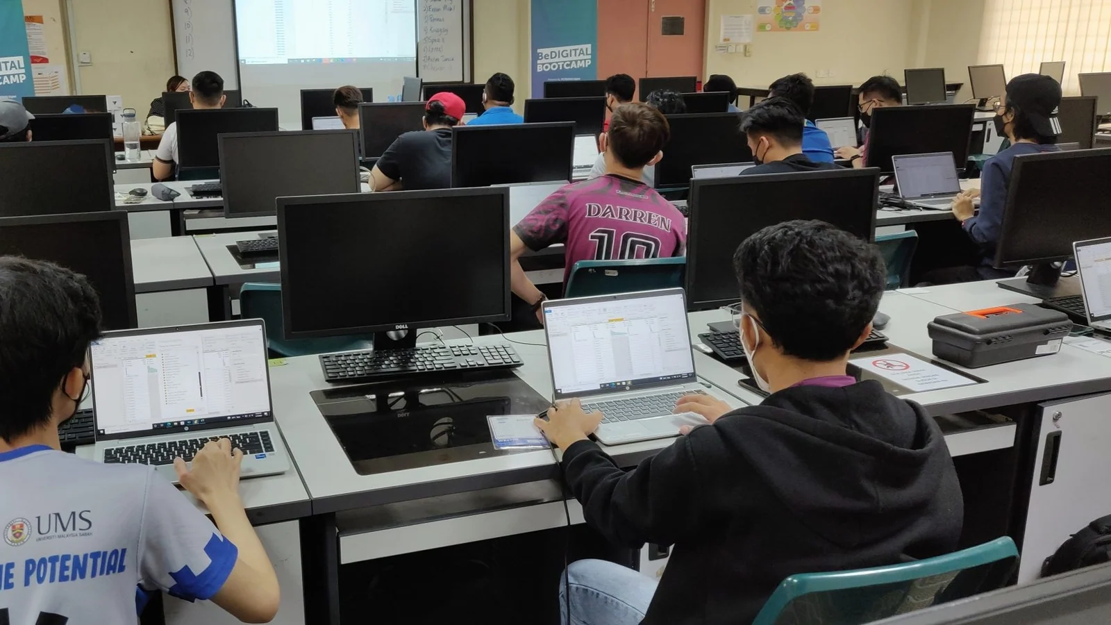 Malaysian university students work at computers during the PETRONAS BeDigital Bootcamp