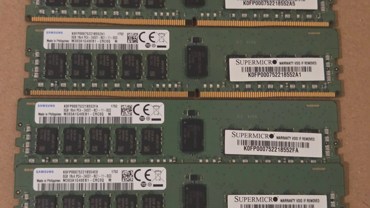 Server memory modules with rows of black memory chips and gold contacts, laid side by side on brown cardboard