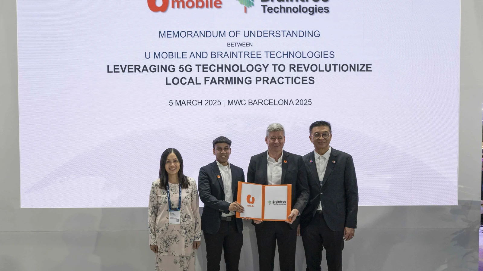 U Mobile and Braintree Technologies representatives sign their smart farming agreement at MWC 2025