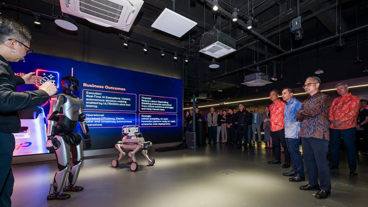 Officials watch a robotics demonstration inside U Mobile's Enterprise Innovation Platform Hub