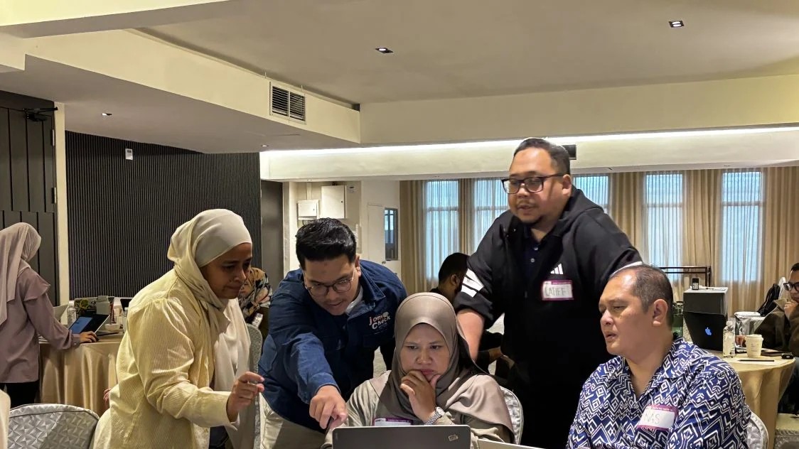AiYOH workshop participants discuss an artificial intelligence exercise around their laptops