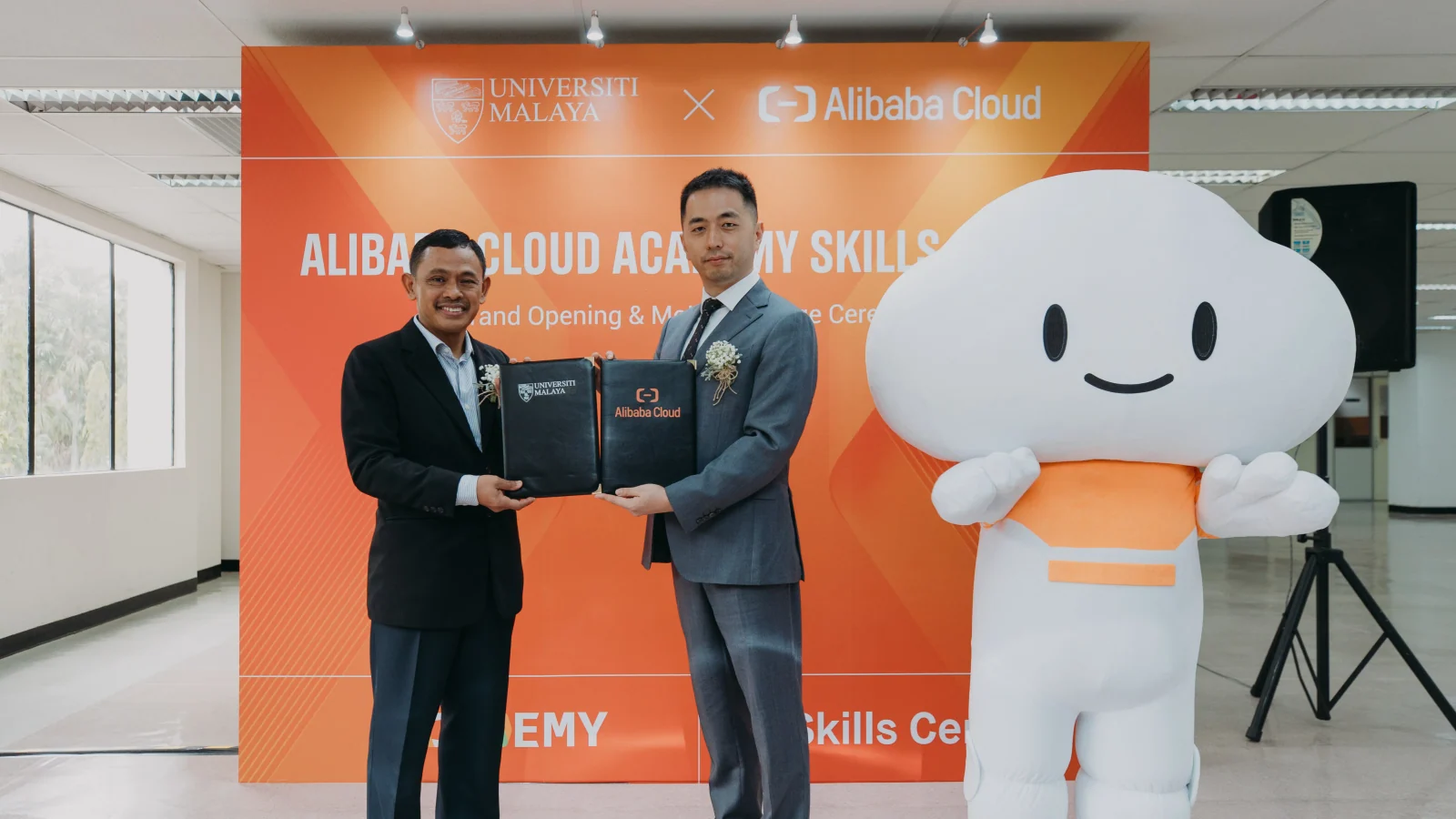 Universiti Malaya and Alibaba Cloud representatives exchange the signed memorandum at the Skills Centre opening