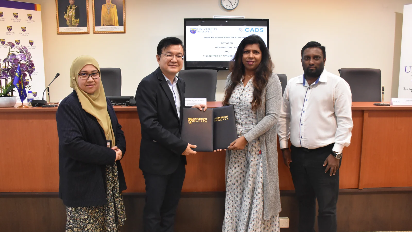 Universiti Malaya and CADS representatives exchange signed partnership documents in 2023