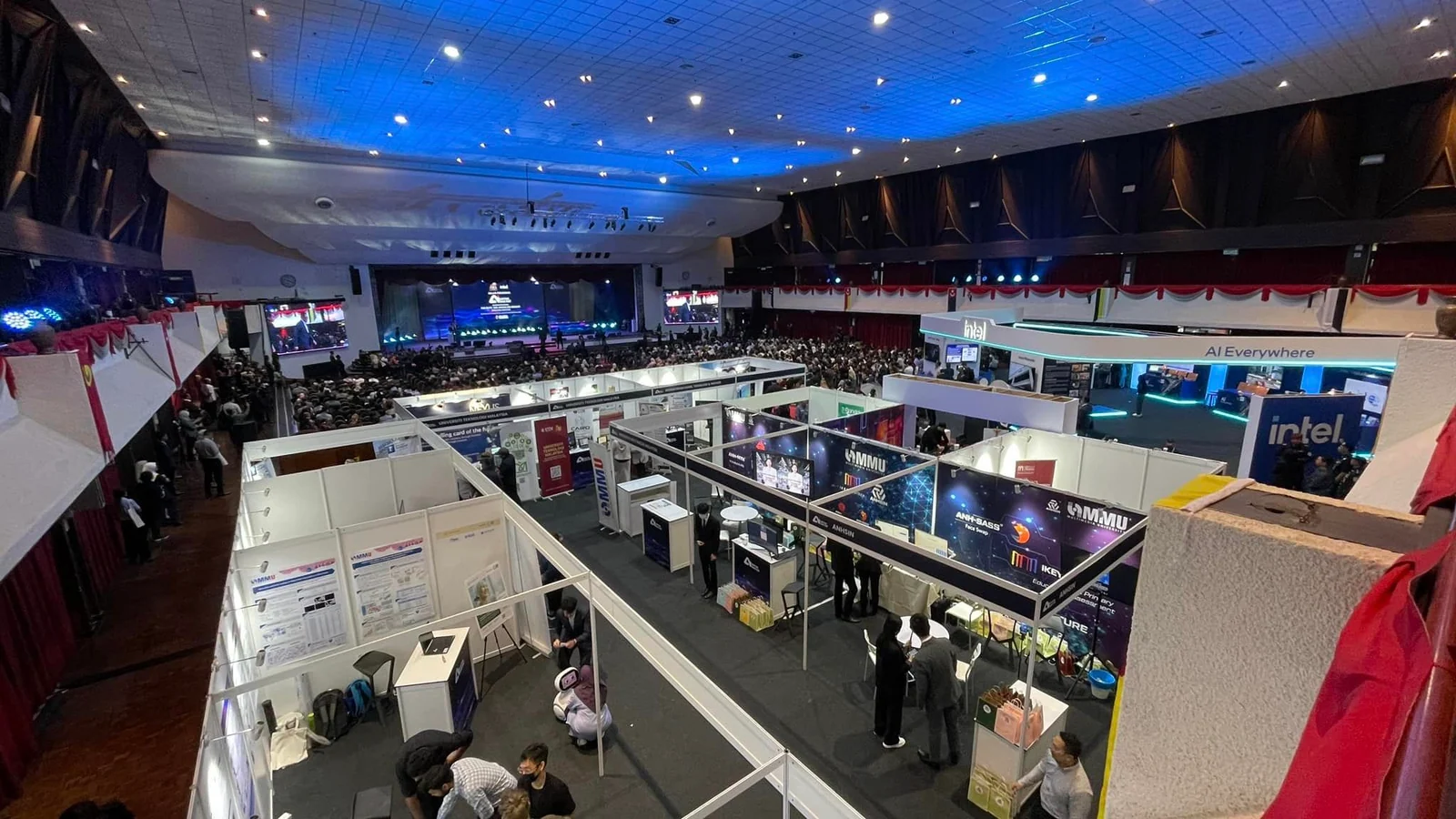 The AI for the People showcase hall at UPM with technology exhibition booths and the main stage