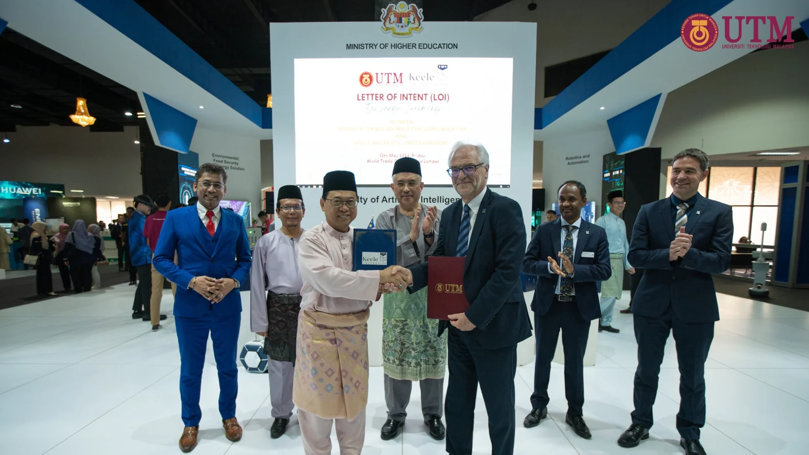 UTM and Keele University leaders exchange folders during the May 2024 Letter of Intent ceremony